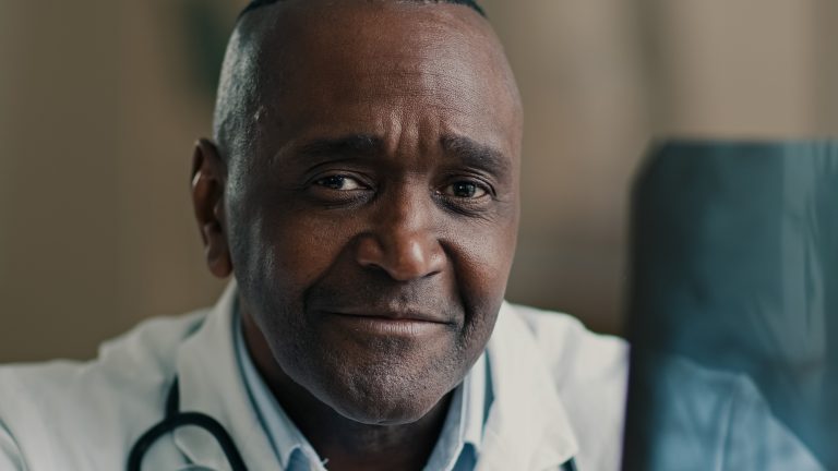 African male medic expert radiologist osteopath surgeon orthopedist ethnic man doctor look at x-ray