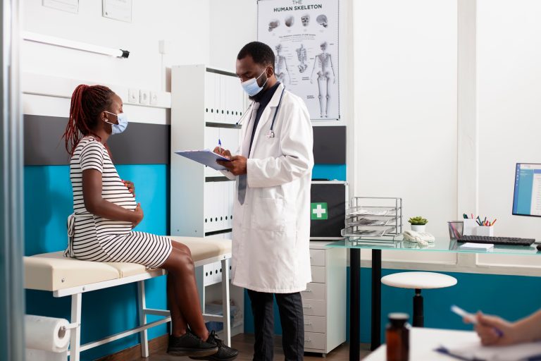 Doctor consults pregnant black woman